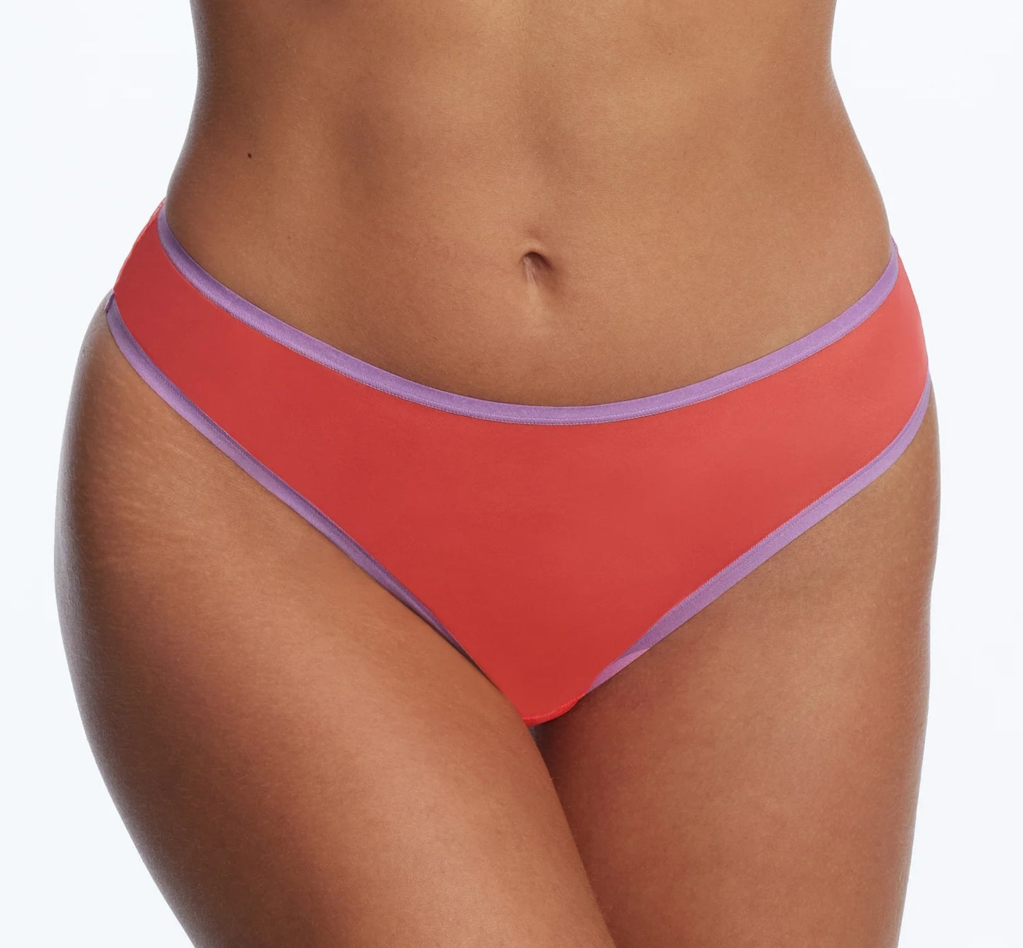A close-up of a model wearing coral red bikini bottoms with a thin light purple trim, shown against a plain white background.