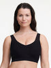 Front of a wireless black bralette with lace straps on model. 