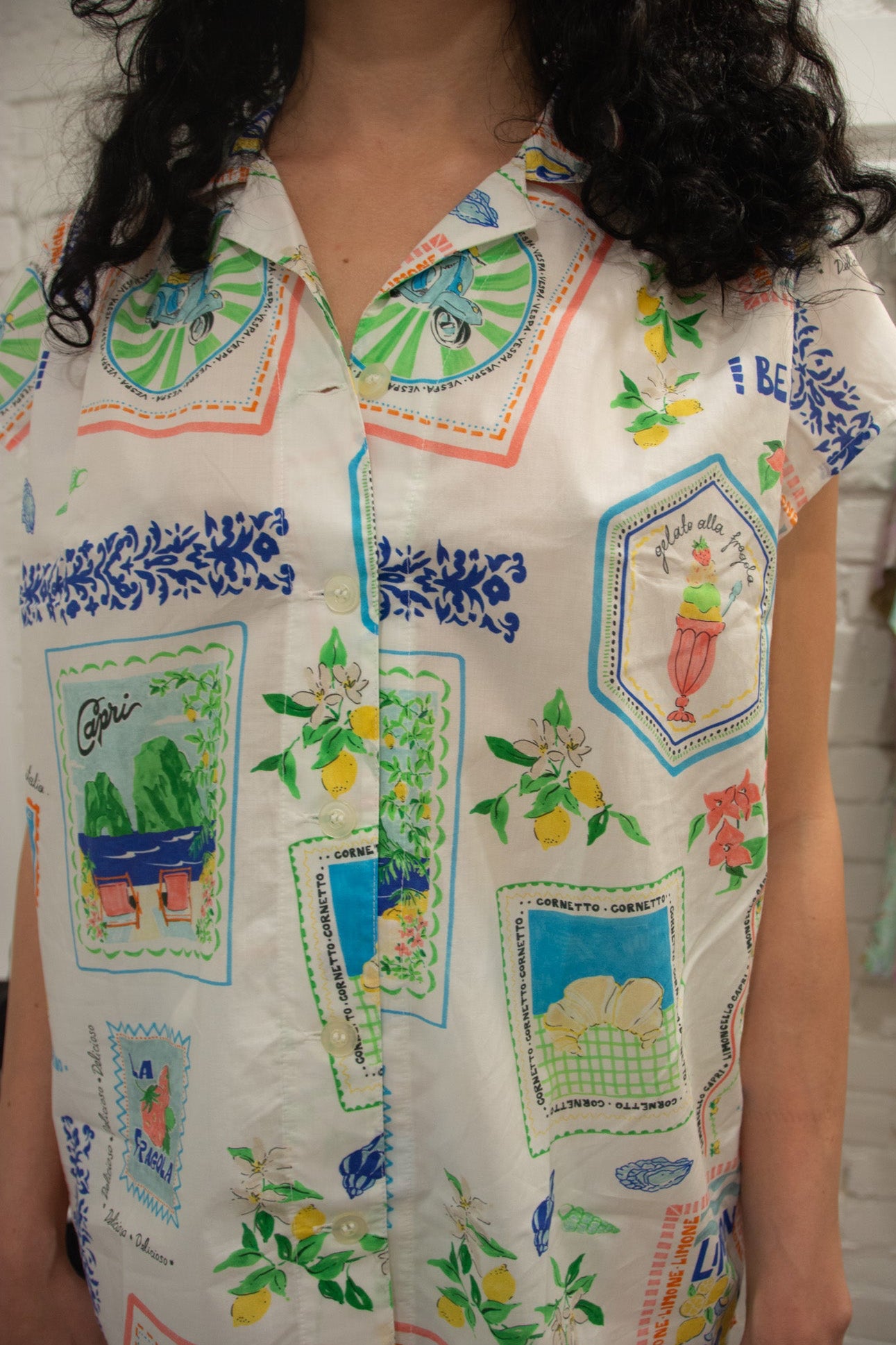 Person wearing a colorful patterned shirt with various designs.