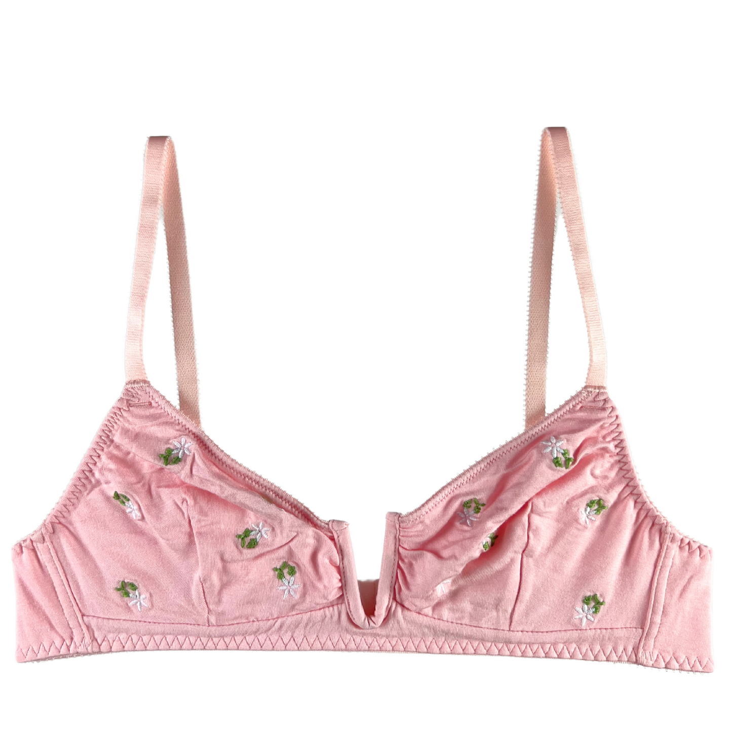 A pink wireless bralette with soft cups, delicate floral embroidery, and adjustable straps.