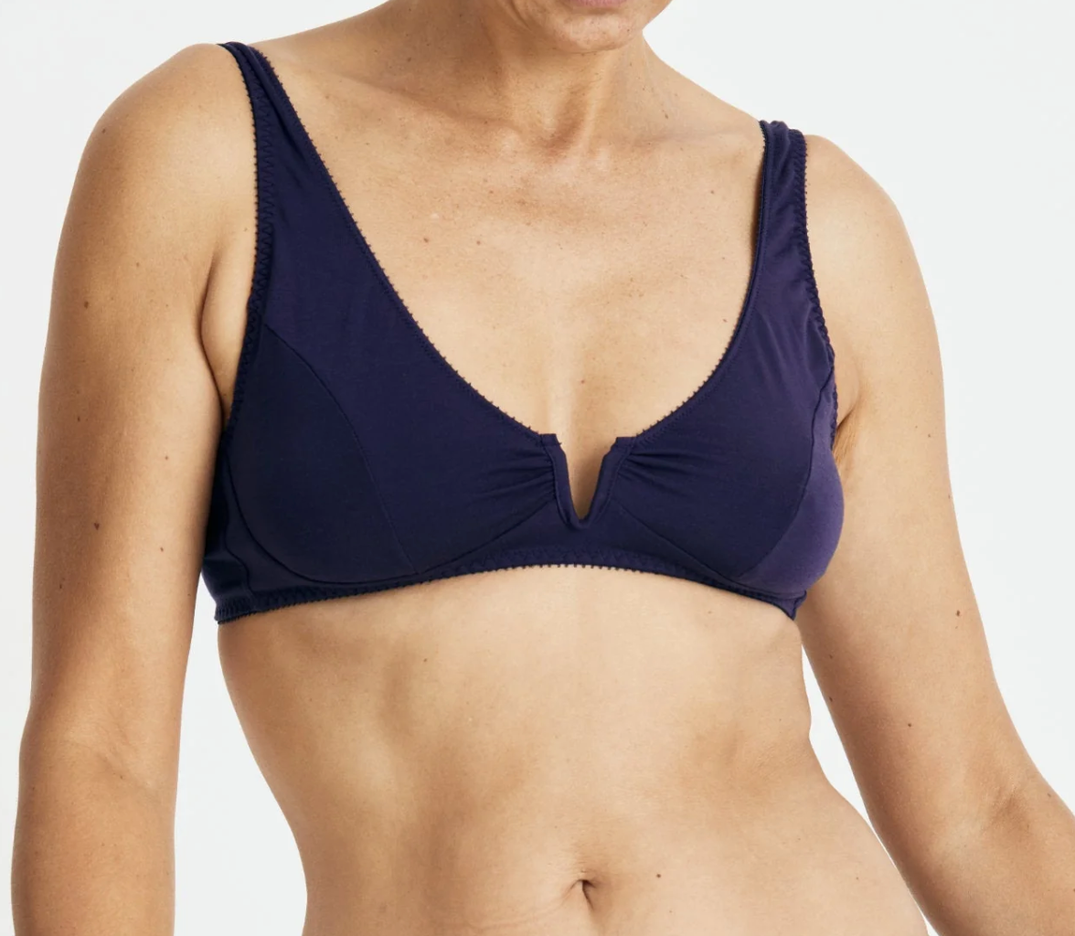 Navy blue bra worn by a person on a white background