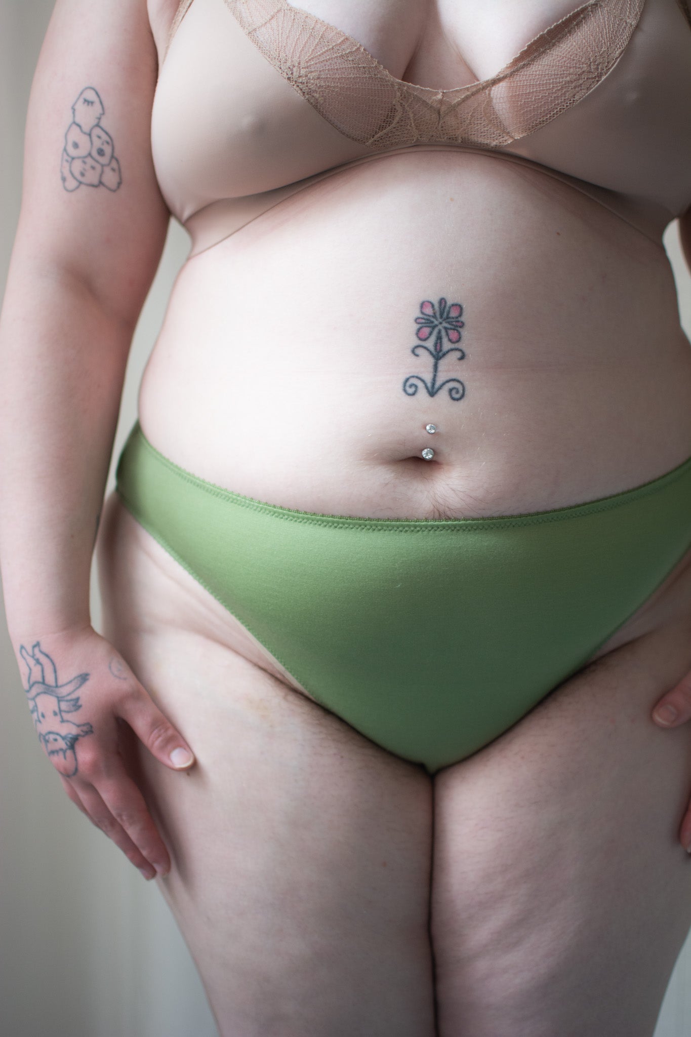 Person wearing green underwear against a neutral background.