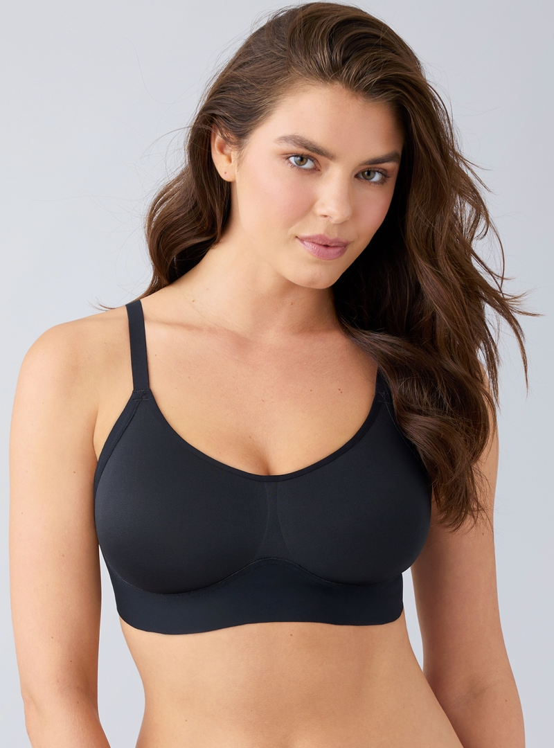 Woman wearing a black bra against a gray background