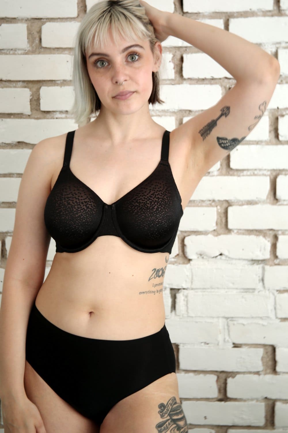 Wacoal Back Appeal full cup bra in black, front view on a model against a brick wall.