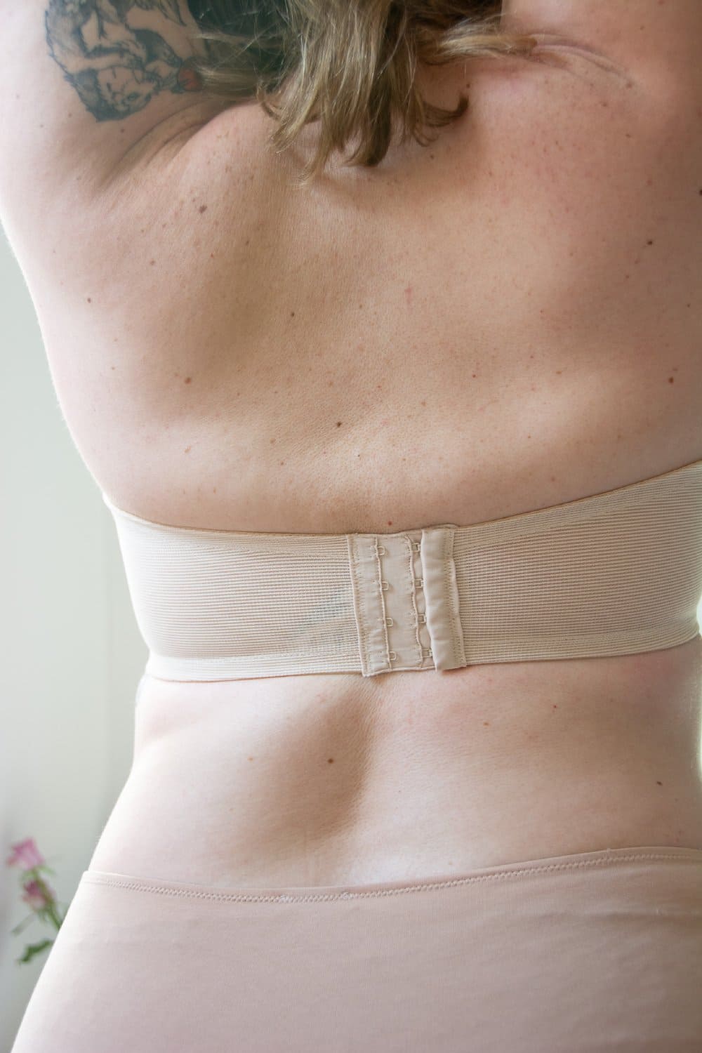 Wacoal visual effects minimizer strapless bra in sand, back close-up on a model.