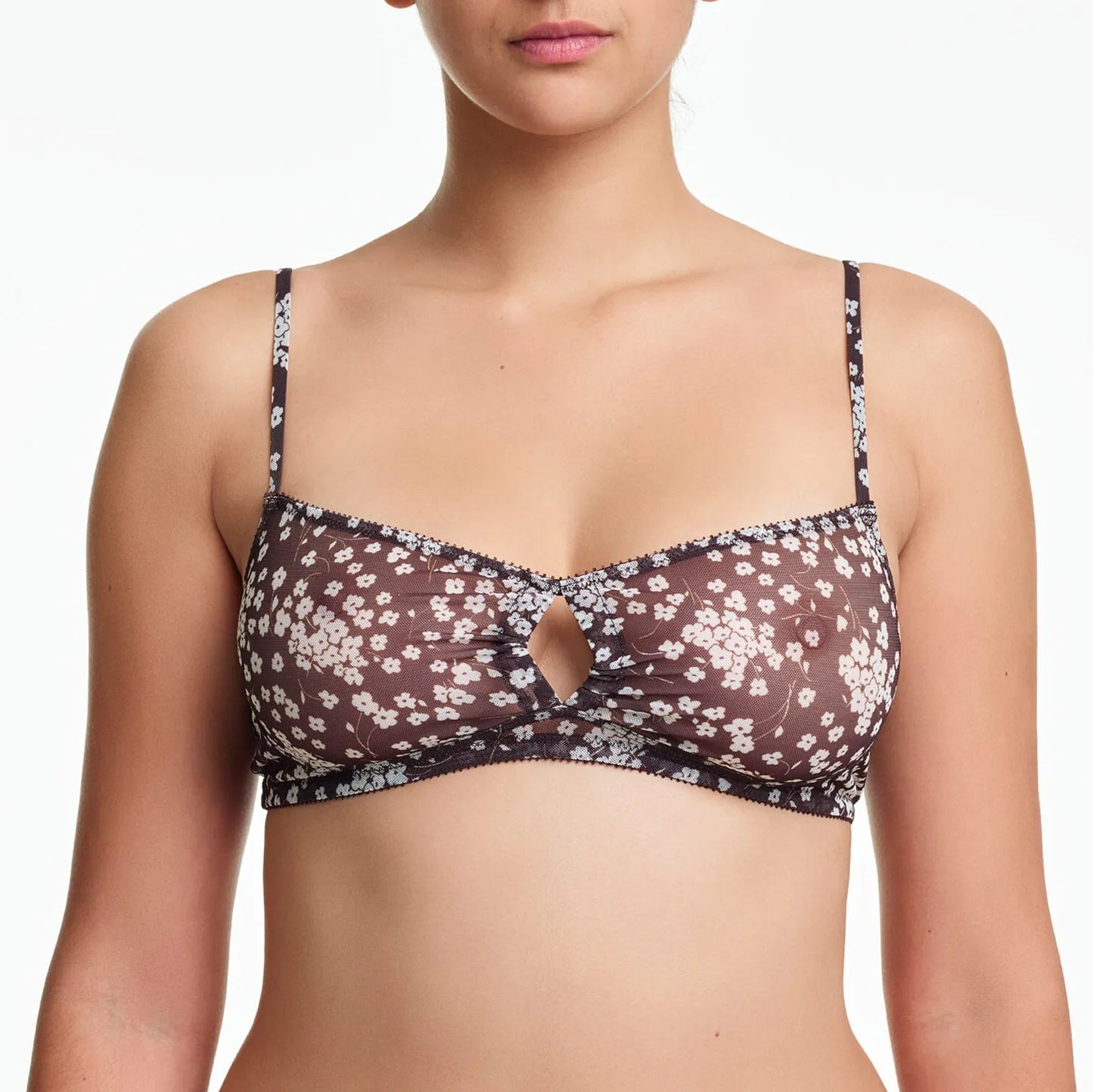 Woman wearing a floral-patterned bralette on a white background
