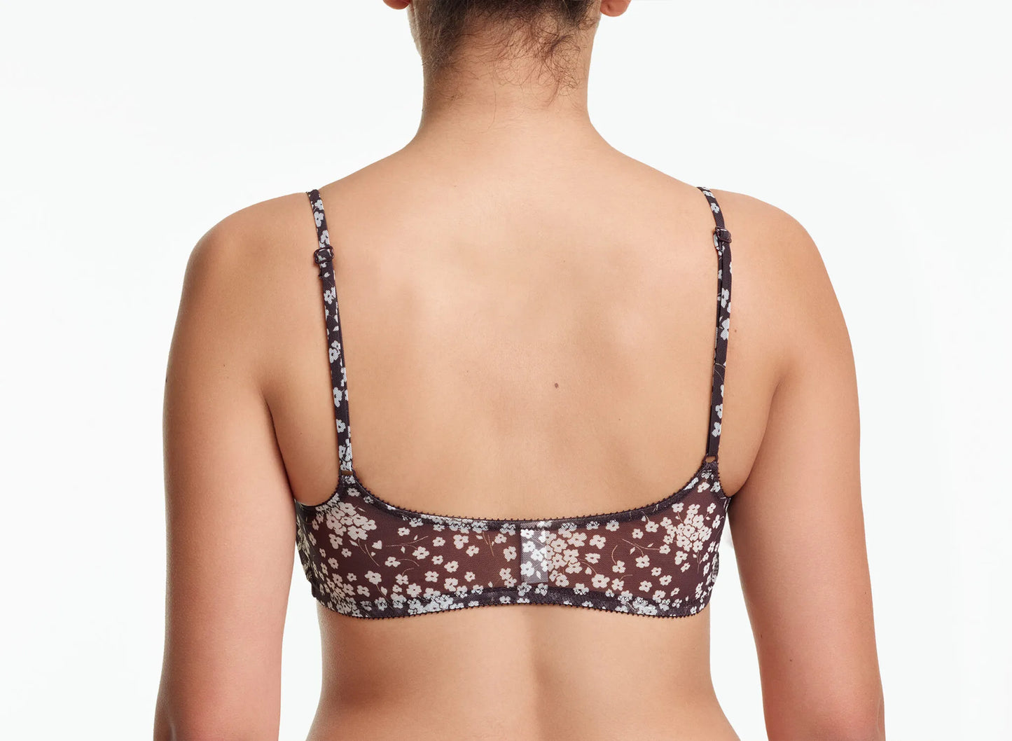 Woman wearing a floral-patterned bralette on a white background