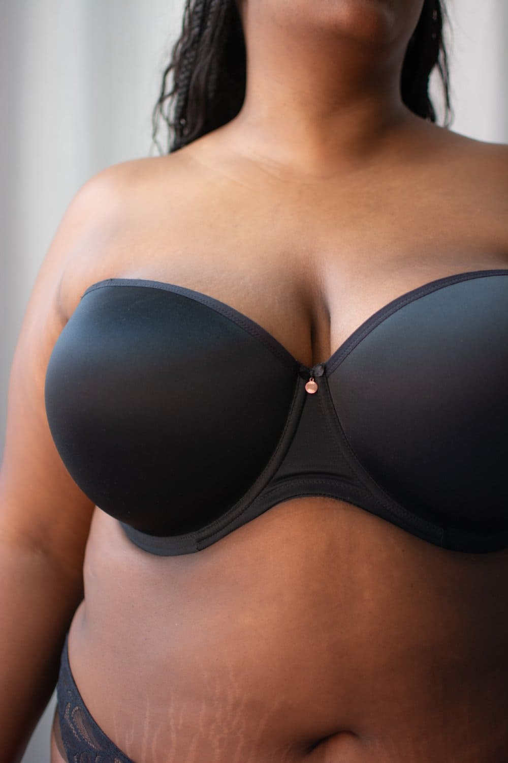 Elomi smooth underwire moulded strapless bra in black, front view on a model, close-up.