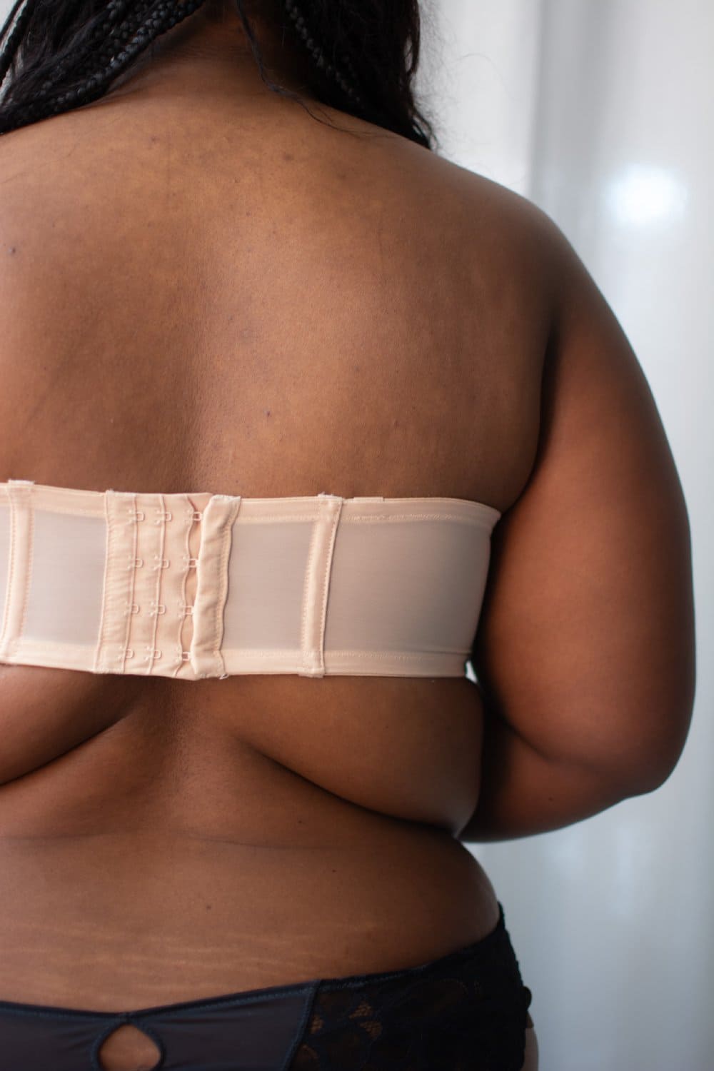 Elomi smooth underwire moulded strapless bra in sahara beige on a model back view, close-up.