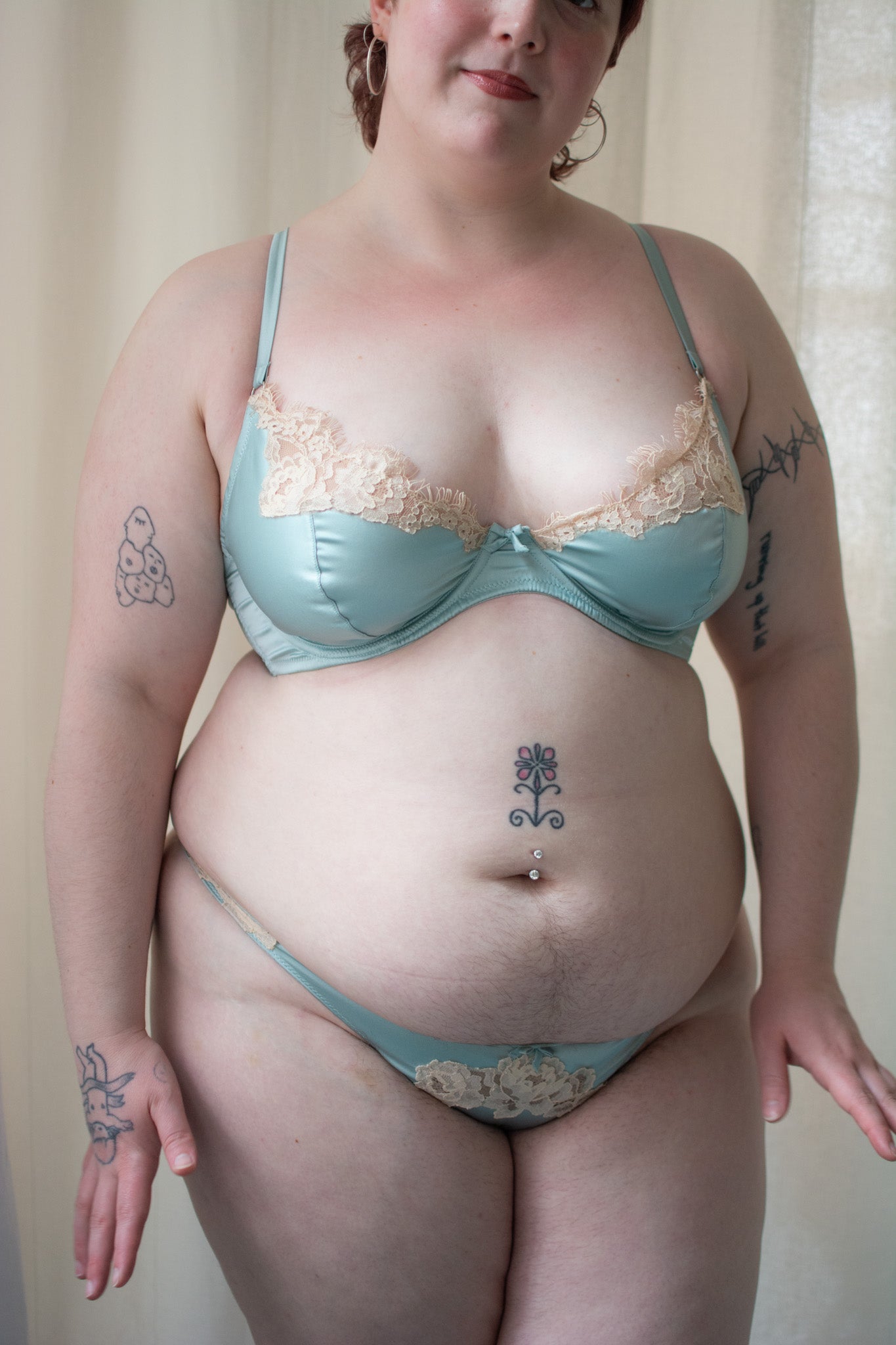 Person wearing a light blue bra and panties set against a neutral background