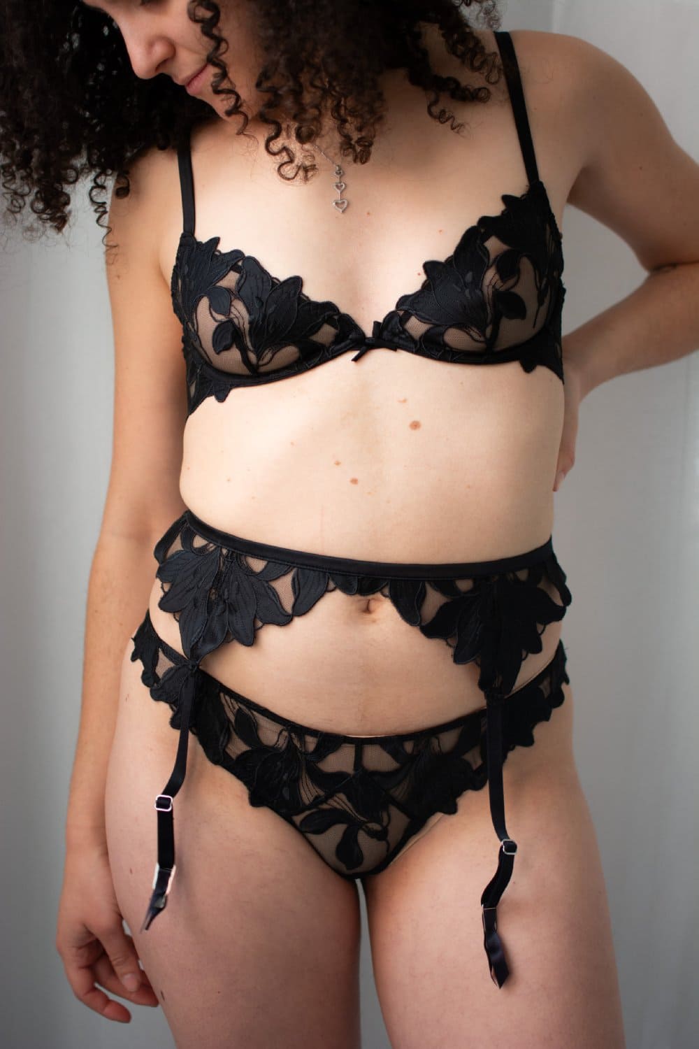 Fleur du mal lily embroidery plunge demi bra in black, front view on a model.