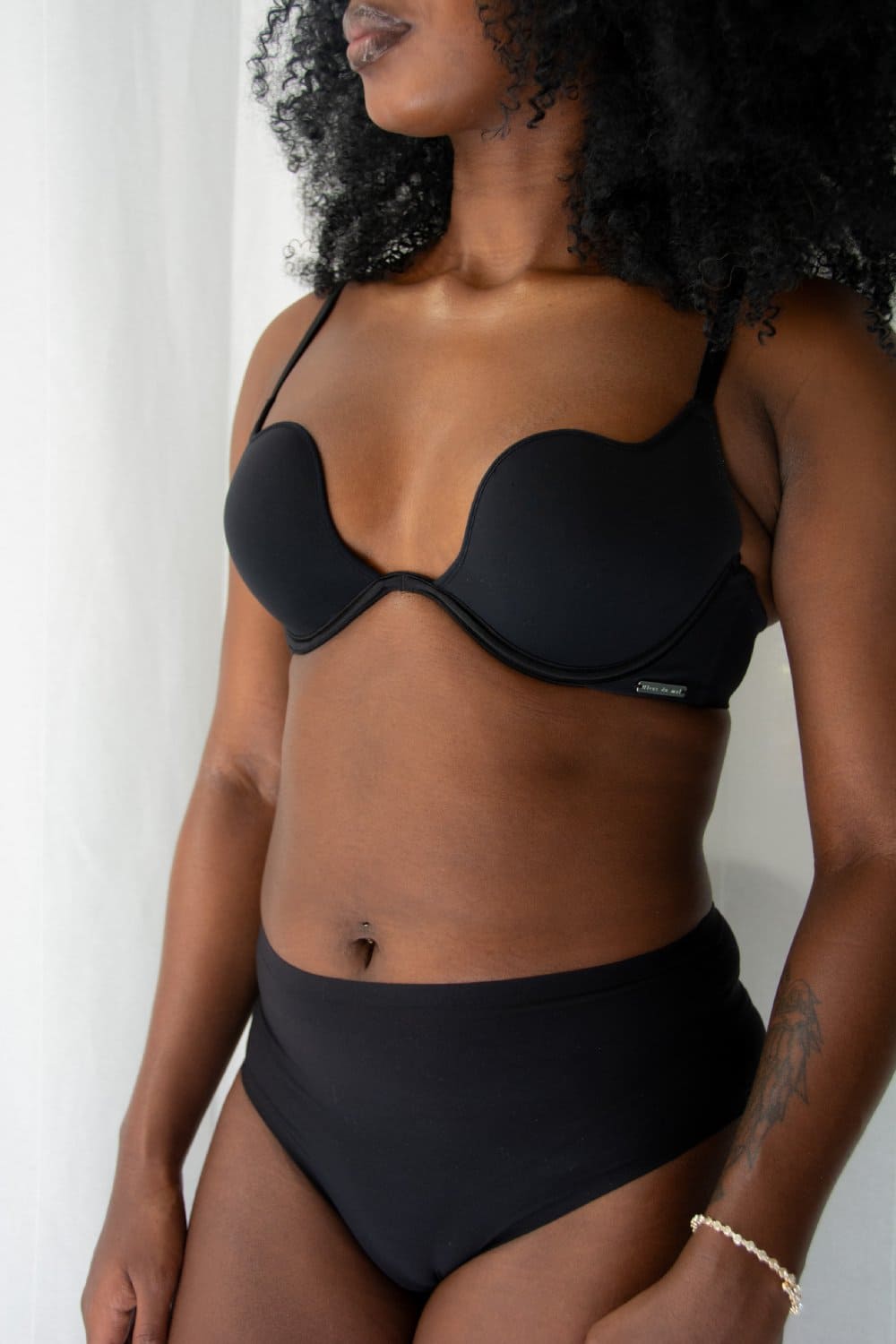 Fleur du mal micro seduce u-plunge bra in black, front view on a model, close-up.