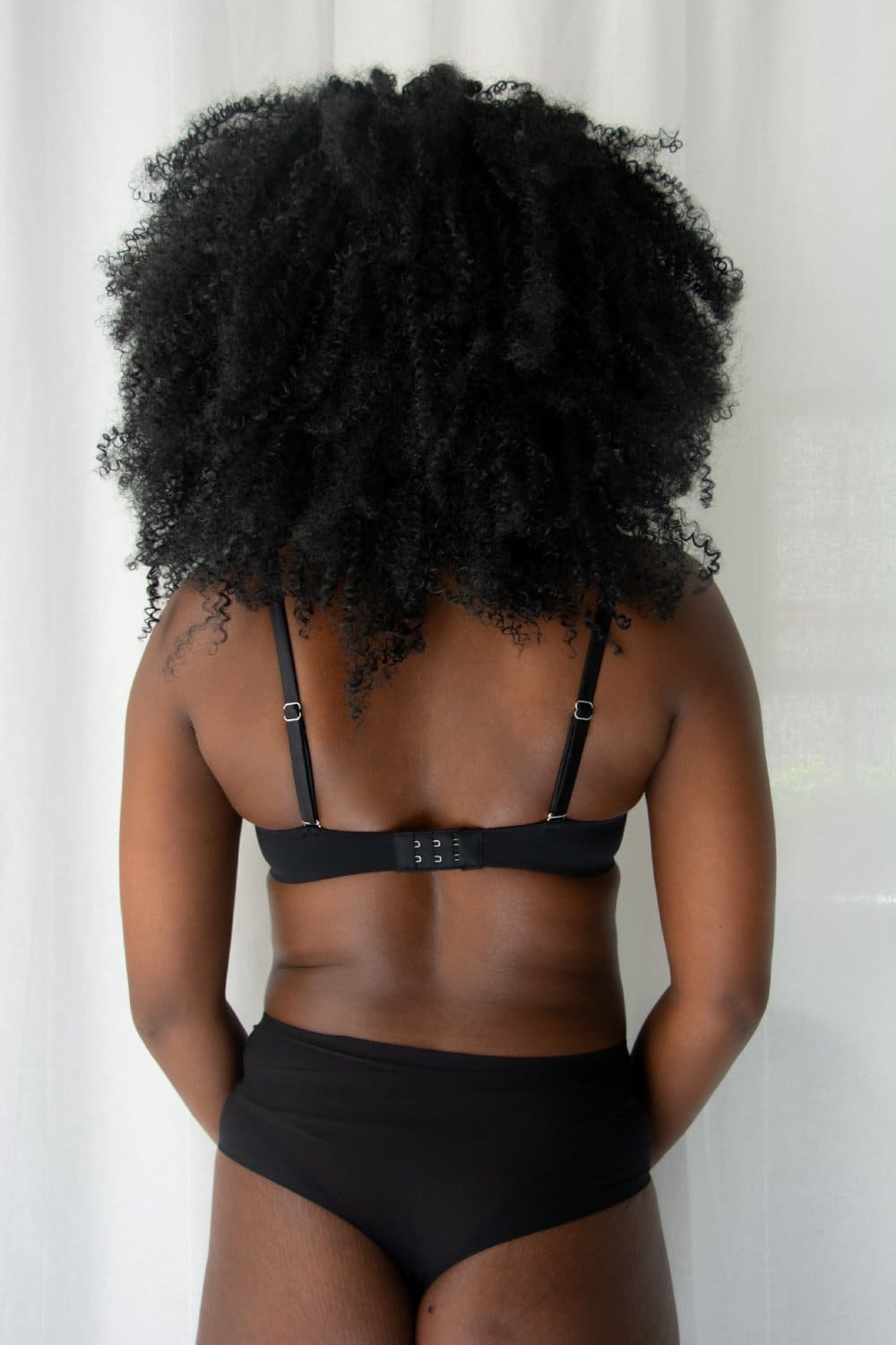 Fleur du mal micro seduce u-plunge bra in black, back view on a model.
