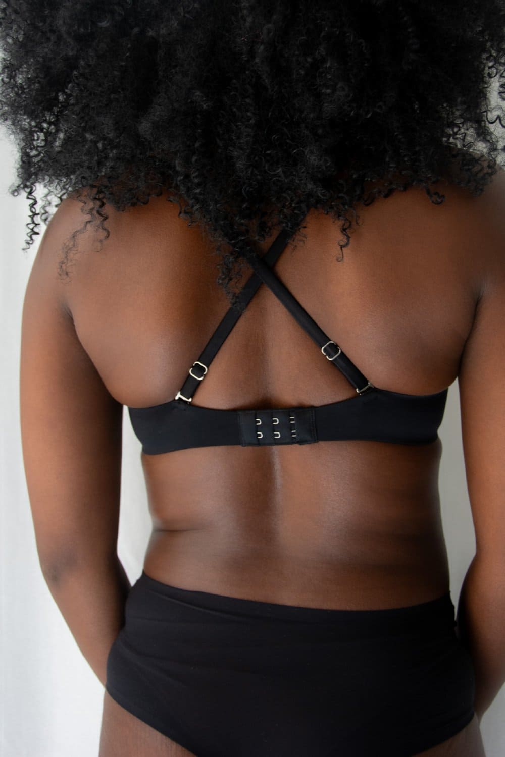 Fleur du mal micro seduce u-plunge bra in black, back view on a model, close-up.