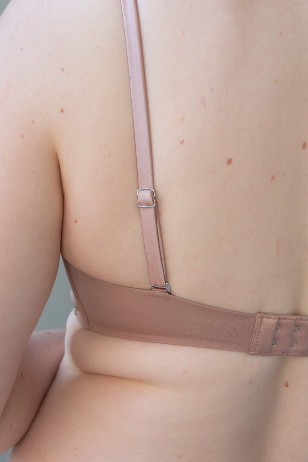 Fleur du mal micro seduce u-plunge bra in tan, back view on a model, close-up.